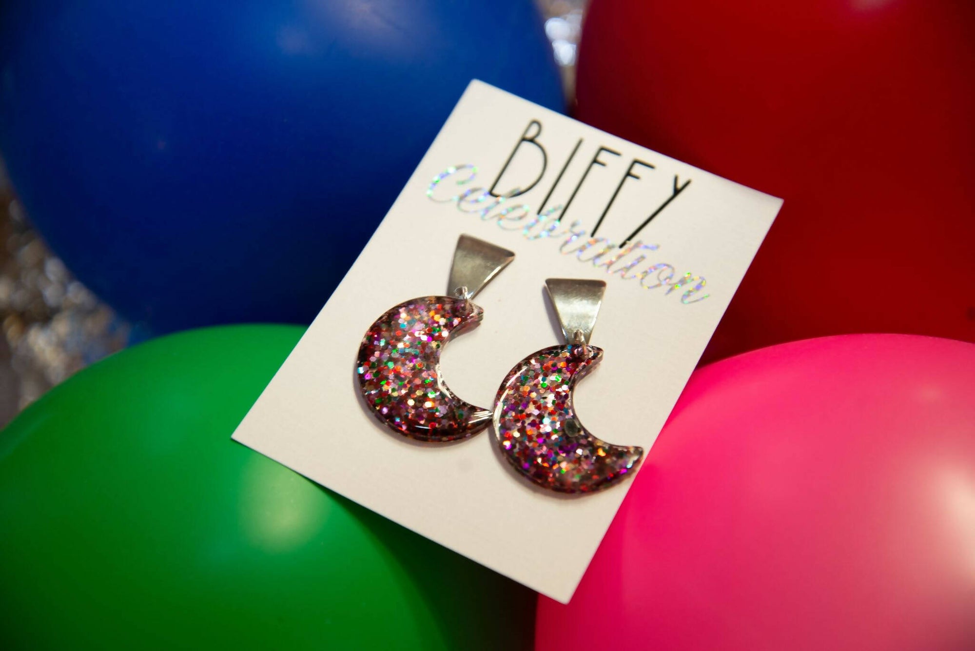 Party Celebration Resin Earrings, Sequin Glitter, Geometric Shapes, Moon, on biffy earring card, on balloon, top view
